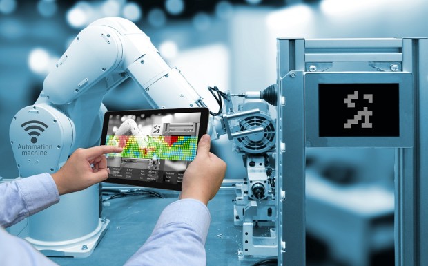 Industry 4.0 concept .Man hand holding tablet with Augmented reality screen software and blue tone of automate wireless Robot arm in smart factory background